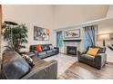 Bright living room with a high ceiling, hardwood floors, neutral walls, a fireplace, and comfortable furniture at 4349 S Genoa Ct, Centennial, CO 80015