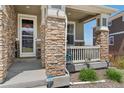 Close-up of a porch with stone pillars, Ring security system, and a view of the neighborhood at 23883 E Minnow Cir, Aurora, CO 80016