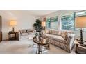 Cozy living room featuring large windows, comfortable seating, and ample natural light at 13934 W Warren Dr, Lakewood, CO 80228