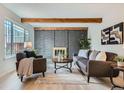 Cozy living room with wood beam ceilings, brick fireplace, and neutral decor at 1251 S Yosemite Way # 92, Denver, CO 80247