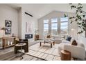 Spacious living room featuring vaulted ceiling, large windows, fireplace, and modern furnishings at 959 Promenade Dr, Superior, CO 80027