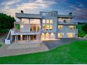 Back exterior with a full view of the house, beautiful balcony, patio and lush green lawn at 7330 Centennial Dr, Parker, CO 80138
