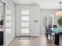 Modern entryway featuring neutral colors, tiled floor, front door with window inserts, and coat hooks at 3368 Cranston Cir, Highlands Ranch, CO 80126