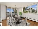 Bright dining room featuring hardwood floors, a modern chandelier, and sliding glass doors to a balcony with city views at 740 N Pearl St # 203, Denver, CO 80203