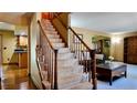 Charming staircase features carpeted steps and wood banister, leading to the home's upper level at 16639 E Berry Ln, Centennial, CO 80015