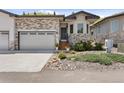 Charming home featuring stone accents, a two-car garage, and a welcoming front entrance at 6835 Surrey Trl, Littleton, CO 80125