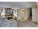 Cozy living room with brick fireplace, mounted television, plush carpeting, and neutral decor at 562 W Crestline Cir # 7D, Littleton, CO 80120