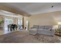 Bright living room with plush carpeting, sectional sofa, adjacent dining area, and natural light at 562 W Crestline Cir # 7D, Littleton, CO 80120
