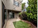 Relaxing backyard features string lights, artificial turf, concrete patio, and privacy at 1233 S Yosemite Way # 74, Denver, CO 80247