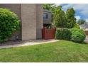 Exterior view of the unit with lush grass, mature trees and a wooden gate at 1233 S Yosemite Way # 74, Denver, CO 80247