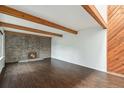 Spacious living room with a brick fireplace, hardwood floors and wood beam ceiling at 1233 S Yosemite Way # 74, Denver, CO 80247