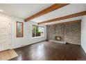 Bright living room featuring a brick fireplace and exposed wood beams at 1233 S Yosemite Way # 74, Denver, CO 80247