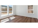 Cozy bedroom with hardwood floors, white walls, and well-lit windows with views at 11487 E Briarwood Cir, Centennial, CO 80112