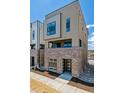 Modern townhome featuring brick base, neutral siding, and contemporary windows under a bright sky at 11487 E Briarwood Cir, Centennial, CO 80112