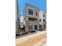 Modern townhome with brick base, beige siding, and a clean, contemporary design on a sunny day at 11487 E Briarwood Cir, Centennial, CO 80112