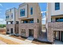 New townhome exterior with modern design, brick base, and neutral siding on a sunny day at 11487 E Briarwood Cir, Centennial, CO 80112