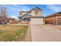 Inviting two-story home boasts a well-manicured lawn, a two-car garage, and a classic architectural design at 1706 Ghost Dance Cir, Castle Rock, CO 80108