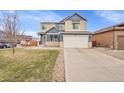 Inviting two-story home boasts a well-manicured lawn, a two-car garage, and a classic architectural design at 1706 Ghost Dance Cir, Castle Rock, CO 80108