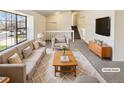 Bright living room features neutral tones, large windows, and staircase access at 16750 E Ada Pl, Aurora, CO 80017
