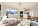 Cozy living room with a large window, modern fireplace, and an open view into the kitchen at 2896 W Riverwalk Cir # A102, Littleton, CO 80123