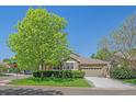 Well-maintained home featuring a green lawn, mature trees, and an attached two-car garage at 6673 S Benton St, Littleton, CO 80123