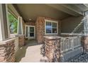 Inviting front porch with stone columns and neutral accents, creating a warm welcome at 6673 S Benton St, Littleton, CO 80123