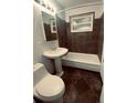 Clean bathroom with dark tile, pedestal sink, and bathtub at 153 S Pierce St, Lakewood, CO 80226