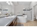 Bright bathroom with double sinks, a soaking tub, and a separate glass-enclosed shower at 4301 S Pierce St # 6D, Littleton, CO 80123