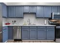 Kitchen with stainless steel appliances, white countertops and a backsplash, and blue cabinets at 4301 S Pierce St # 6D, Littleton, CO 80123