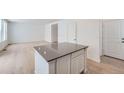 Kitchen island with a dark countertop and white cabinets at 210 Paloma Way, Elizabeth, CO 80107