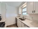 Kitchen with white cabinets and quartz countertops featuring a double sink and stainless steel dishwasher at 1146 Croke Dr, Thornton, CO 80260