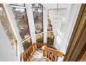 Bright foyer featuring a winding staircase, wood railings, and an elegant chandelier at 3308 S Birch St, Denver, CO 80222