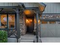 Inviting front porch with stone pillars and charming decor, leading to the front door and attached garage at 6597 Club Villa Rd, Parker, CO 80134