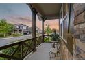 Cozy front porch with a table and chairs, offering a relaxing view of the neighborhood street at 6597 Club Villa Rd, Parker, CO 80134