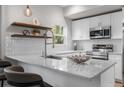 Bright kitchen featuring white cabinets, stainless steel appliances, and a stylish quartz countertop at 2140 S Ash St # 102, Denver, CO 80222
