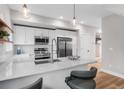 Modern kitchen featuring white cabinets, stainless steel appliances and countertop bar seating at 2140 S Ash St # 102, Denver, CO 80222