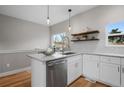 Bright kitchen with an eat-in island, stainless appliances, granite countertops and floating wooden shelves at 2140 S Ash St # 102, Denver, CO 80222
