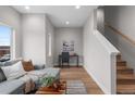 Cozy living room area featuring a gray sofa, desk, and wooden staircase, bathed in natural light at 2140 S Ash St # 102, Denver, CO 80222