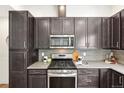 Close-up of the kitchen with stainless steel appliances, light countertops and tile backsplash at 7812 W 43Rd Pl, Wheat Ridge, CO 80033