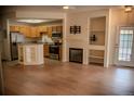Open-concept living room with fireplace, built-in shelves, and hardwood floors at 2980 W Centennial Dr # L, Littleton, CO 80123
