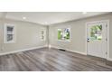 Bright living room with sleek grey flooring, fresh paint, and natural light from updated windows at 3636 Ames St, Wheat Ridge, CO 80212