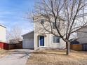 Well-maintained two-story home boasts a blue front door and attached garage at 1242 Bluebird St, Brighton, CO 80601