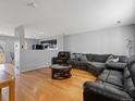 Spacious living room with sleek hardwood floors, a large sofa, and an open floor plan at 1242 Bluebird St, Brighton, CO 80601