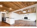 Inviting living room with a unique wood ceiling, brick fireplace, and an open floor plan to the kitchen at 7695 Quitman St, Westminster, CO 80030