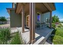 Close-up view of a welcoming front porch with seating, charming details, and attractive landscaping at 19120 E 54Th Pl, Denver, CO 80249