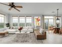 Bright living room with a ceiling fan, expansive windows, and stylish furniture adjacent to the dining room at 13456 Via Varra # 401, Broomfield, CO 80020