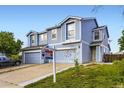 Well-lit exterior of a two-story townhome featuring a manicured lawn and inviting curb appeal at 11120 Josephine Way, Northglenn, CO 80233