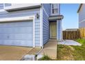 Close-up view of a townhome highlighting the front door, garage, and tidy landscaping at 11120 Josephine Way, Northglenn, CO 80233