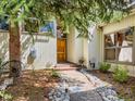 Charming home entrance with stone path, mature trees, and a wooden front door at 2012 Tournament Ct, Evergreen, CO 80439