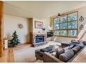 Bright living room with stone fireplace and large window offering natural light at 2012 Tournament Ct, Evergreen, CO 80439